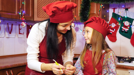 Mother teaches her daughter to work with sugar mastic for decorete cupcakes