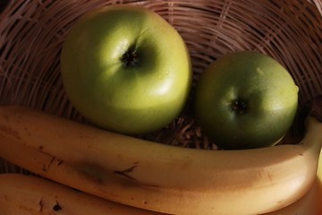 Green apples and bananas on the table