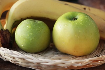 Green apples and bananas on the table