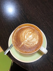 Delicious coffee cappuccino with cinnamon on wooden table