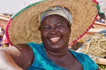 Fröhlich lachende, afrikanische Frau mit Strohhut