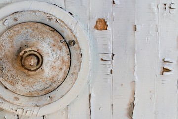 Round aged metal object and a white painted wood panel. Fragment of a vintage abstract installation