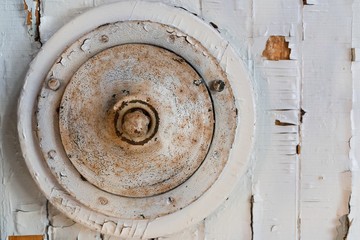 Grungy white wood panel and a round aged metal object. Fragment of an abstract vintage installation