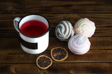 Colored marsmallow and fruit tea in metal cup