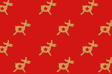 Wooden Christmas toy Deer is lined with a pattern on a red isolated background. Merry Christmas and Happy New Year concept. Minimalistic style. Flat lay, top view