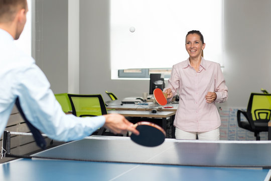 Office Entertainment. Woman And Man Are Playing Together In Table Tennis. Games Between Employees During A Working Break.