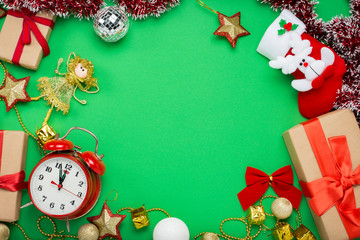 Red alarm clock, Christmas decorations, Christmas toys and gift boxes on a green background. The concept of Merry Christmas and New Year. Flat lay, top view. Copy space