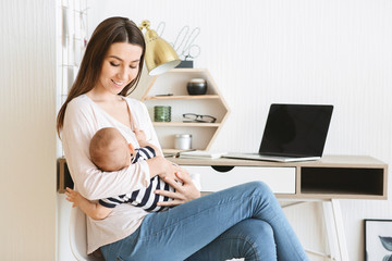 Portrait of mom freelancer with baby in arms