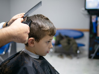 young boy having a hair cut at the hair salon
