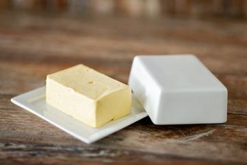 food and dairy products concept - close up of butter on wooden table