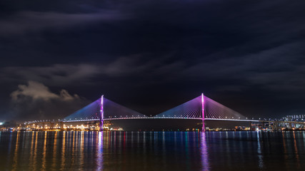 Fototapeta na wymiar Night view of the Busan Harbor Bridge illuminated, connecting the Yeongdo and Nam districts in Busan, South Korea.