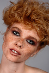 Closeup macro portrait of female face. Human woman half-face with day beauty makeup. Girl with perfect skin and freckles.