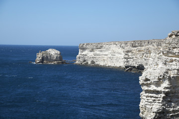 Fototapeta na wymiar High coast, a cliff overhangs the sea, a stone coast.