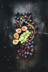 Ripe Grapes and Figs  are mixed on this autumnal food and drink compositiion, top view, naturla light and desaturated tonality to add mood and atmosphere.