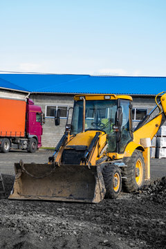 The Yellow All-wheel Drive Backhoe Loader Stands On The Yard Ready For Workind On Construction Site.