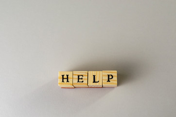 Help word made of letters and wooden cubes