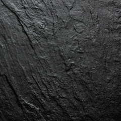 A natural background made of black wild stone close-up. View from above