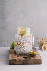 Chia pudding with fresh figs on a glass jar, clean background, minimal style, food blogging.