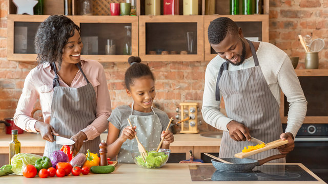 Mom And Daughter Watching Dad While Cooking Together