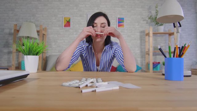 young woman sits at a table quits smoking and is treated for addiction