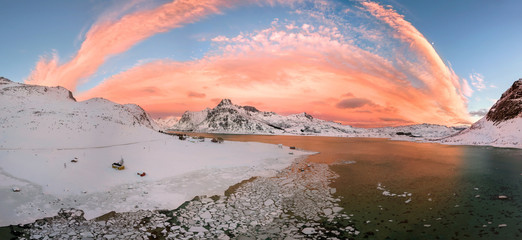 Aerial drone panorama photo. Beautiful sunset over the mountains and sea of the Lofoten Islands. Reine, Norway. Winter landscape with amazing colors.