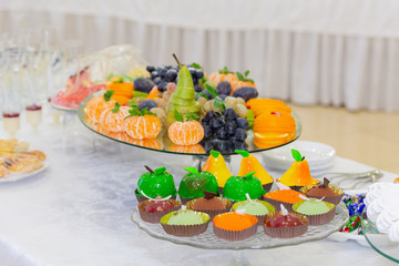 Various fruits, desserts, pastries on the holiday table. New year or Christmas.