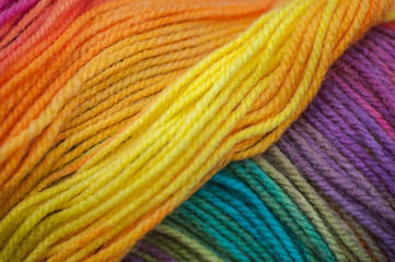 Abstract of skein of rainbow colored acrylic threads in a rollt with selective focus