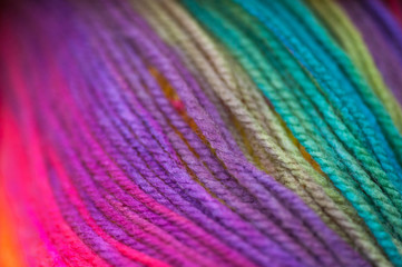 Skein of vivid rainbow colored acrylic threads in free placement background