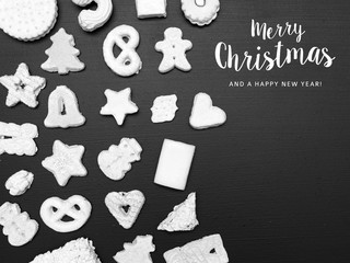 many different white christmas cookies on black background from above