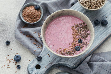 Pink yogurt smoothie bowl made with fresh blueberry and seeds