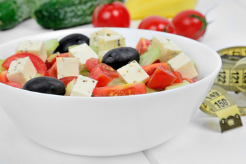 Vegetable salad in a bowl on a wood table with centimeter