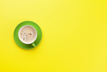 Green coffee cup over yellow background