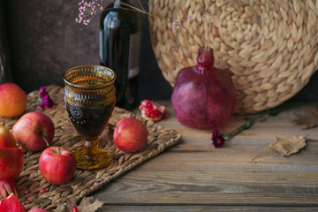 Harvest of red apples, grapefruit with glass of red wine, autumn leaves and flowers