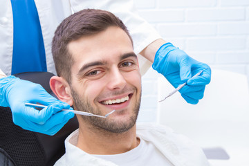 Naklejka premium smiling young man at the dentist's office