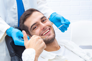 patient at the dentist smiling with signal okay