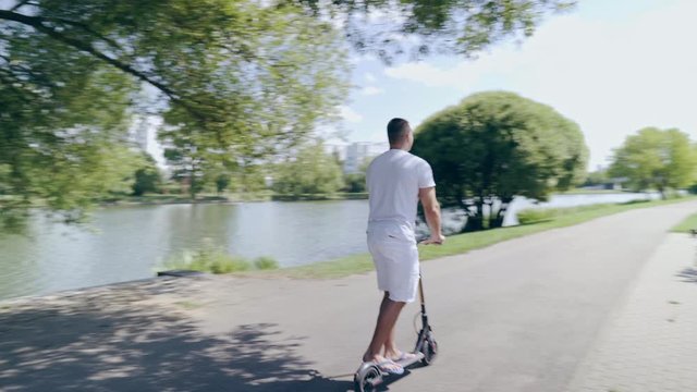 Multiethnic man ride electric scooter along the river