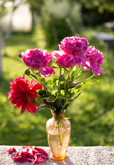 bouquet of flowers on a wooden table in a glass vase and fallen petals