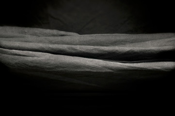 horizontal folds of black photography studio background cloth.      