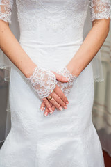 Beautiful bride's hands in white gloves closeup