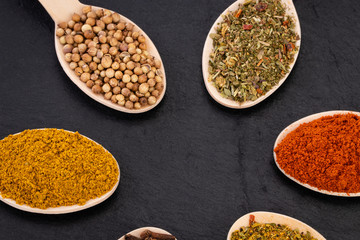 Colourful various herbs and spices on dark background. Top view