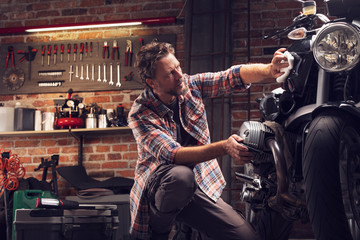 Fototapeta na wymiar Man polish motorcycle in garage