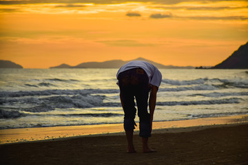 Man stand alone on beach at twilight