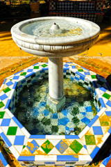 Fototapeta na wymiar Close-up of a beautiful ornamental fountain decorated with tiles in the Murillo Gardens of Seville, Andalusia, Spain