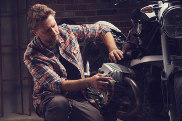 Plakat Collector or mechanic working on a motorcycle