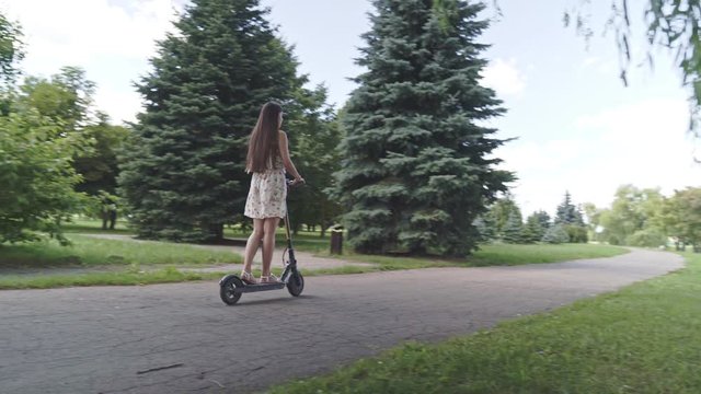 Multiethnic woman ride electric scooter along the river