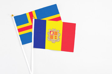 Andorra and Aland Islands stick flags on white background. High quality fabric, miniature national flag. Peaceful global concept.White floor for copy space.