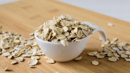 close-up, oatmeal in a white bowl on a wooden plank