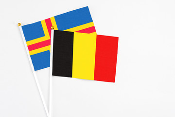 Belgium and Aland Islands stick flags on white background. High quality fabric, miniature national flag. Peaceful global concept.White floor for copy space.