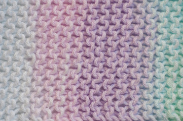 Fragment of handmade seamless knitted patterns in mixed pastel colors