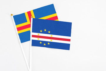 Cape Verde and Aland Islands stick flags on white background. High quality fabric, miniature national flag. Peaceful global concept.White floor for copy space.
